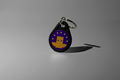 Our purple keychain Totem with a yellow logo on a gray background. Used to aid focus for ADHD and students. Totem Focus.