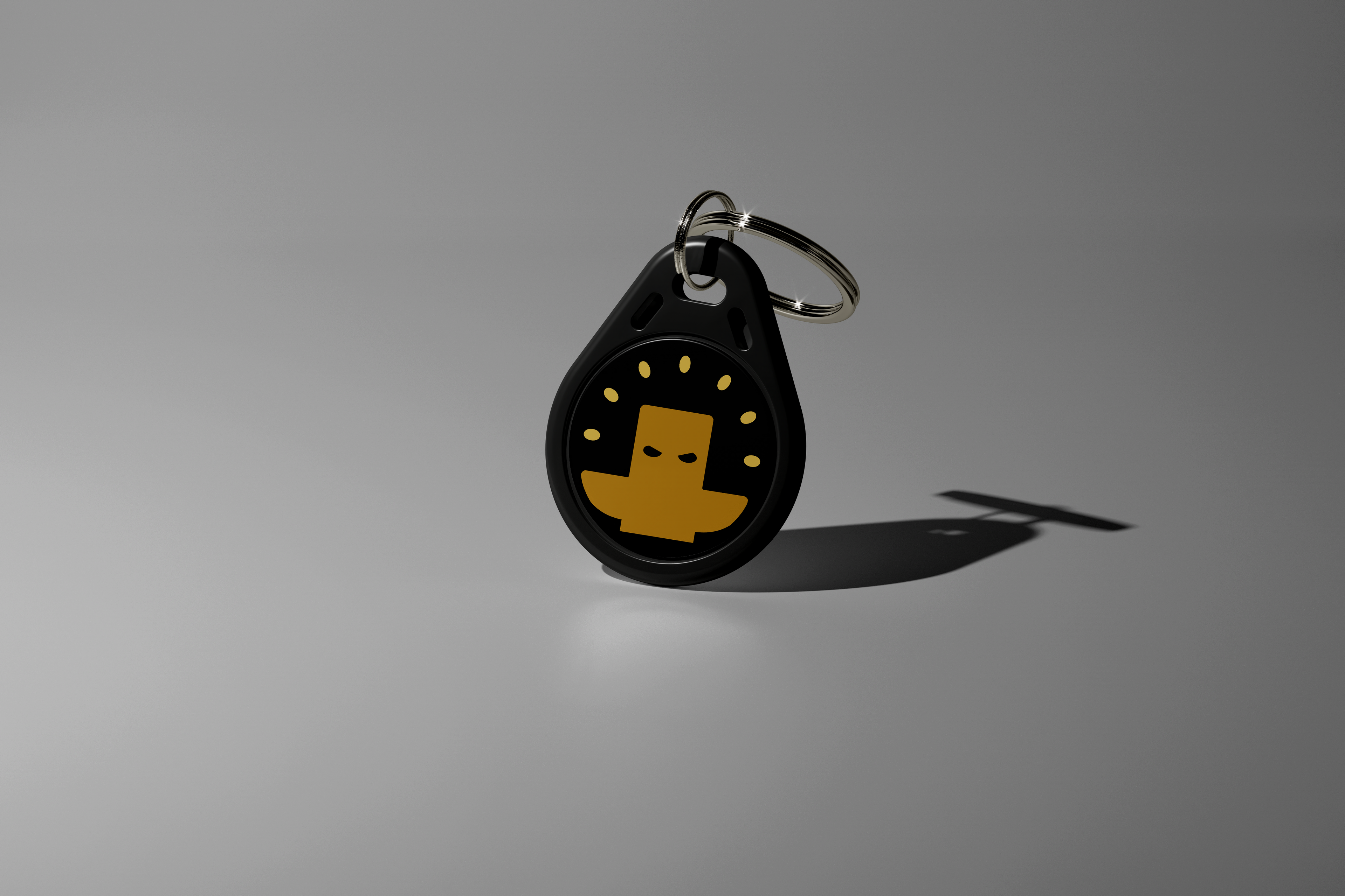 Our black keychain Totem with a yellow logo on a gray background. Used to aid focus for ADHD and students. Totem Focus.