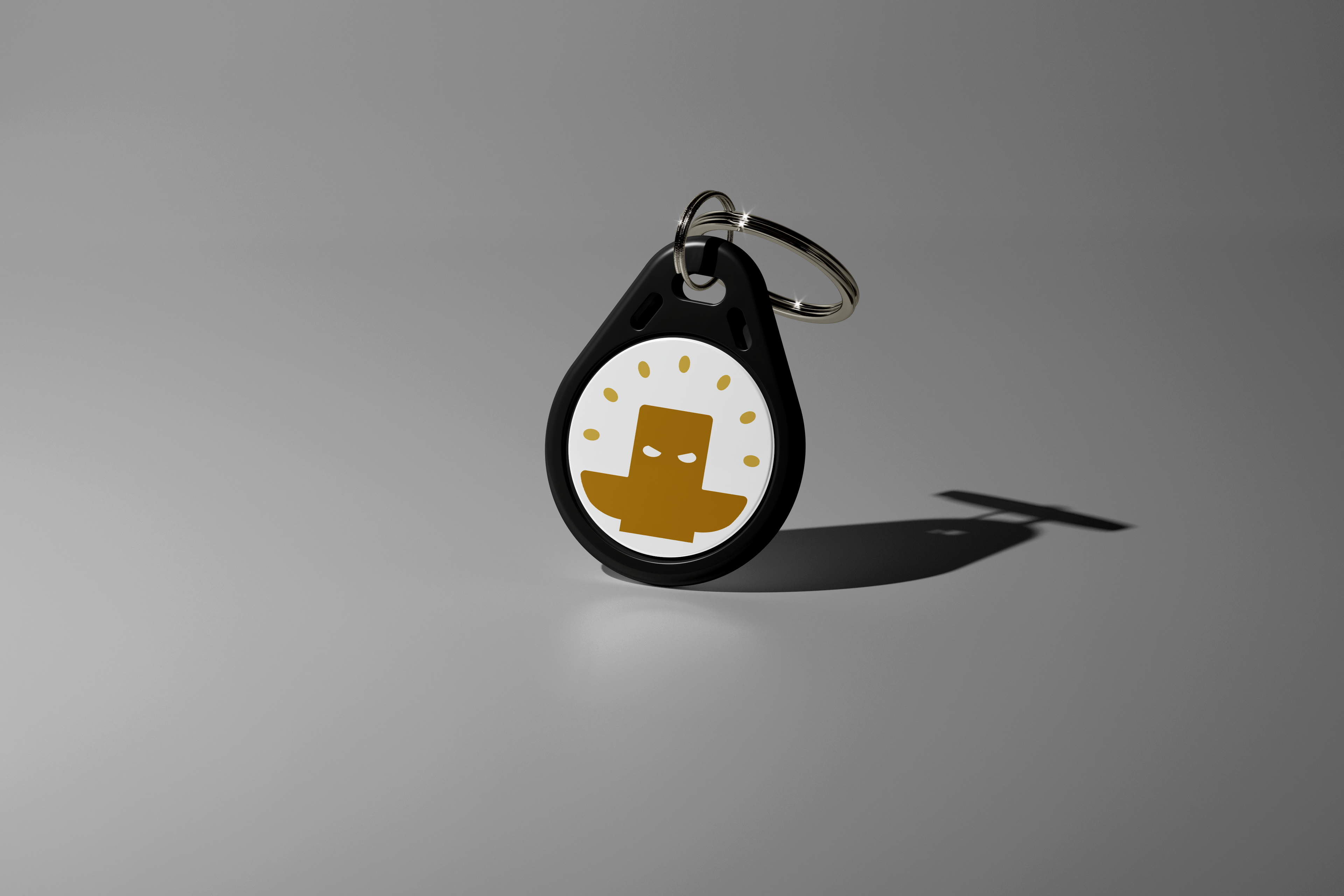 Our white keychain Totem with a yellow logo on a gray background. Used to aid focus for ADHD and students. Totem Focus.